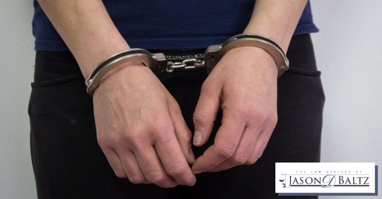 Young adult male in handcuffs